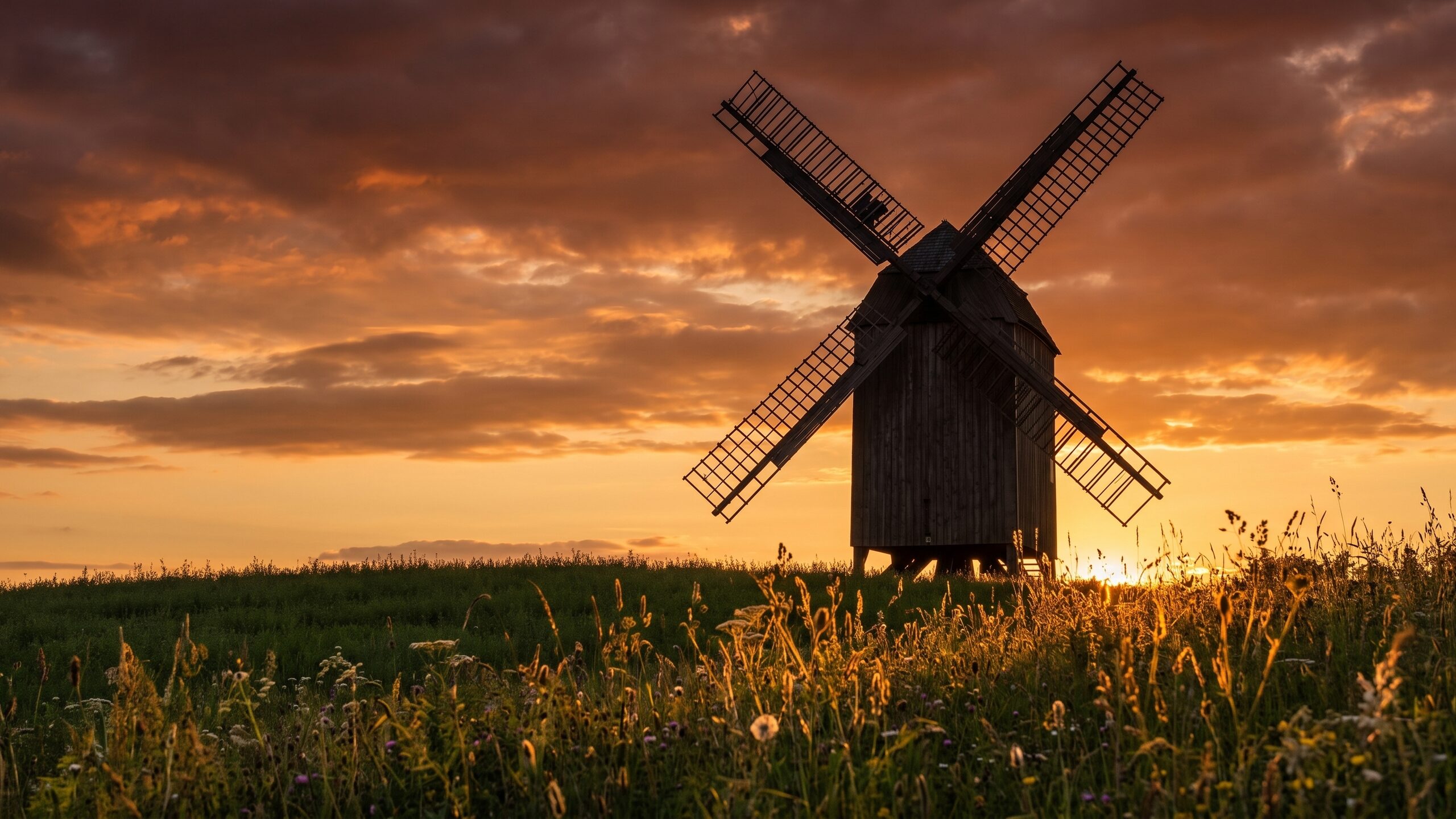 Die Windmühle als Silhouette vor dem Abendhimmel.